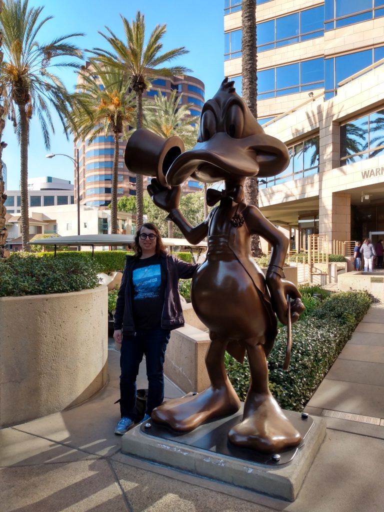 Danielle Solzman poses with Daffy Duck in front of the Warner Brothers Studio tour entrance.