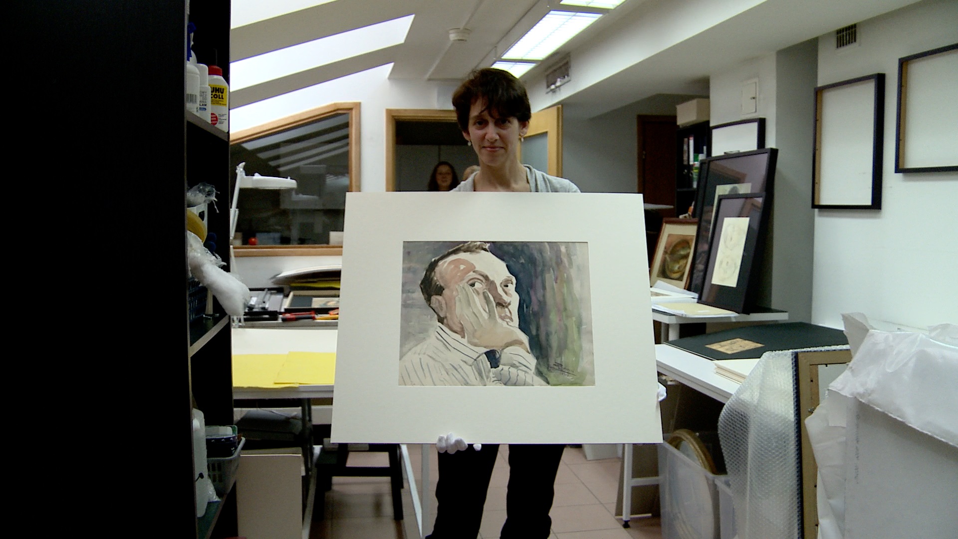 Elizabeth Rynecki holding her great-grandfather's self-portrait at the Jewish Historical Institute in Warsaw in Chasing Portraits.