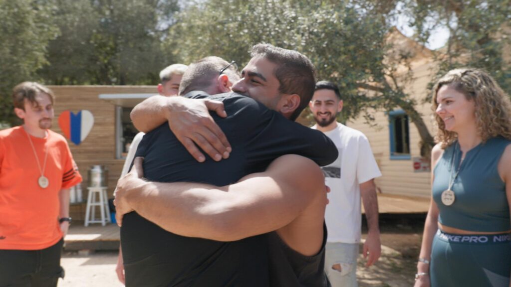 Oz Davidian hugs an October 7 survivor that he saved in a still from Oz's List.